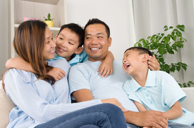 Happy family sitting on sofa at home