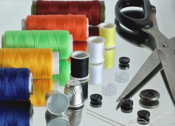 Close-up of sewing items on glass table