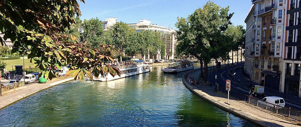 Scenic view of canal by buildings against sky