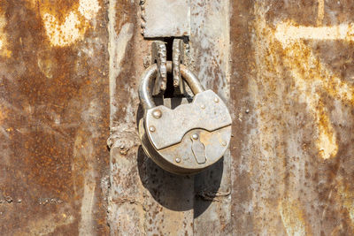 Close-up of padlock on old door