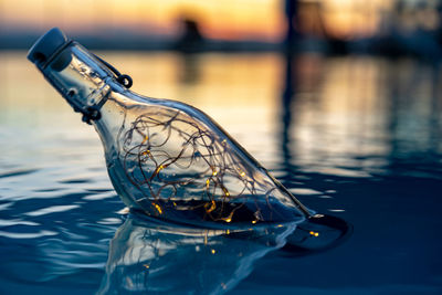 Close-up of illuminated light in bottle floating on lake