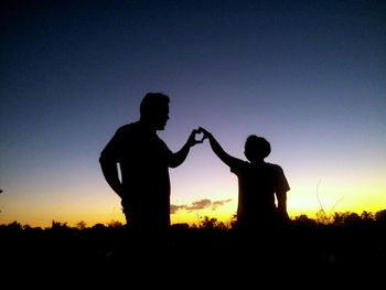 Silhouette people against clear sky during sunset
