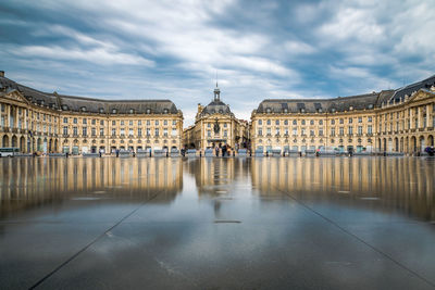 Buildings in city against cloudy sky