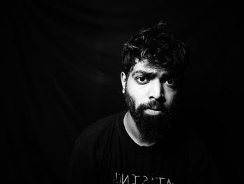 Portrait of man against black background