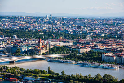 High angle view of illuminated city by river against sky