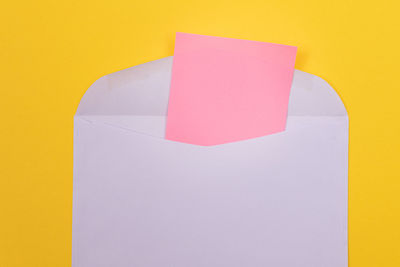 Close-up of paper against yellow wall