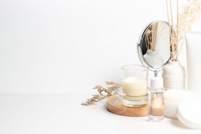 Close-up of glass jar on table against white background