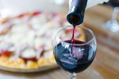 Close-up of wine pouring in glass on table