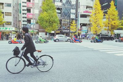 Side view of a woman with bicycle on road