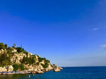 Scenic view of bay against clear blue sky