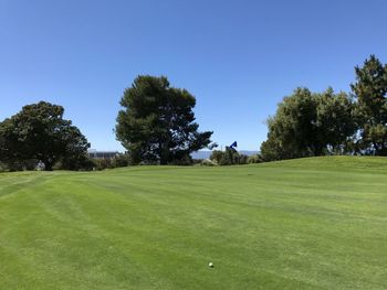 View of golf course against clear sky