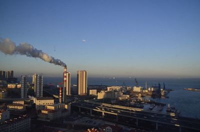 Smoke emitting from factory against clear sky