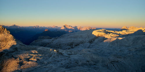 Scenic view of snowcapped mountains against clear sky during sunset