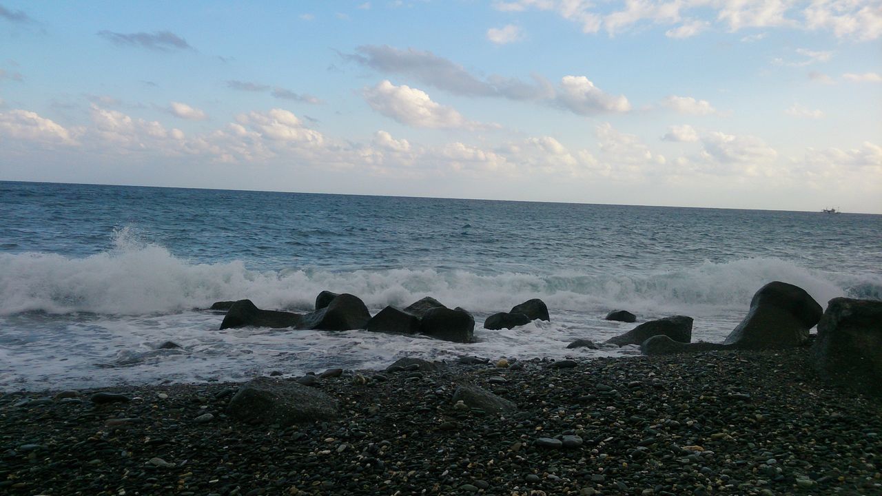 ROCKS ON BEACH AGAINST SKY