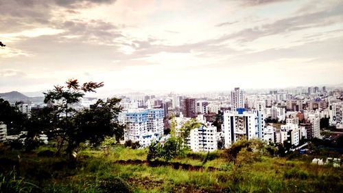 View of cityscape against cloudy sky