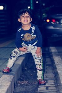 Portrait of boy in city at night