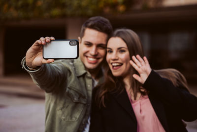 Portrait of smiling young woman using mobile phone