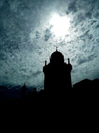 Low angle view of silhouette built structure against cloudy sky