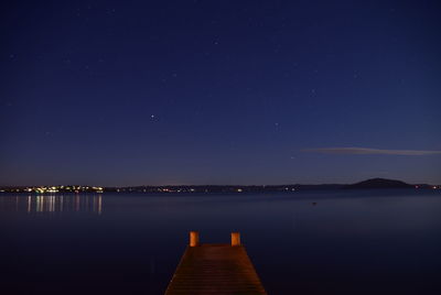 Scenic view of lake against sky at night