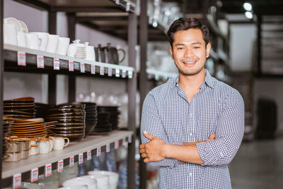 Portrait of young man standing against wall