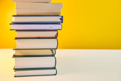 Close-up of books against yellow background