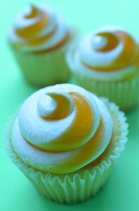 Close-up of mango cupcakes on green table