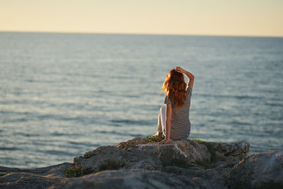 Rear view of woman looking at sea against sky