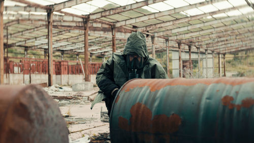 Man with gas mask near radioactive barrels