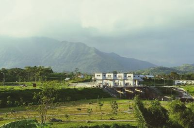 Scenic view of buildings and mountains against sky