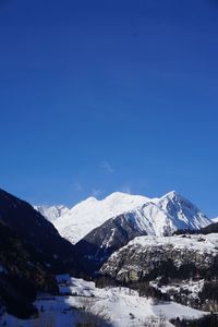 Scenic view of snowcapped mountains against clear blue sky