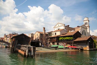 Canal amidst buildings against sky