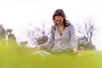 Young woman with arms raised on field