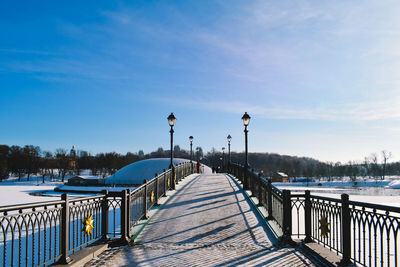 Pier over lake against blue sky during winter