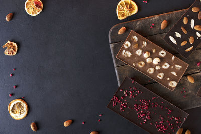 Organic chocolate bars with sublimated berries, orange slices and nuts. copy space.