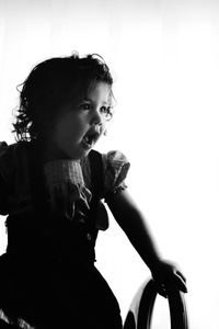 Cute baby girl looking away against white background