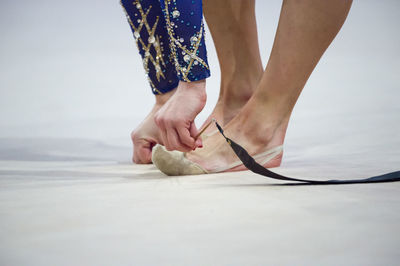 Low section of dancer wearing shoe on floor