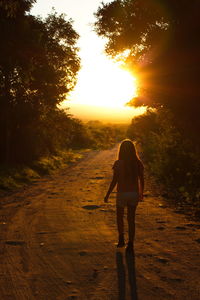 Rear view of woman standing on road