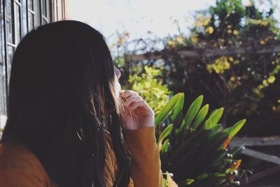 Side view of thoughtful woman at backyard