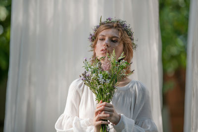 Portrait of woman holding flower bouquet