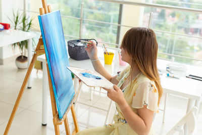 Woman sitting on table at home