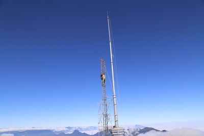 Low angle view of communications tower against clear blue sky