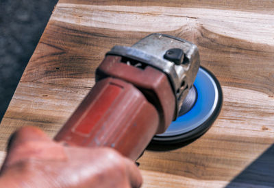 Close-up of human hand holding wooden table