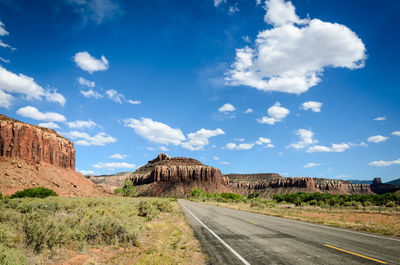 Road leading towards mountains against sky
