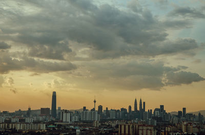 Modern buildings in city against sky during sunset