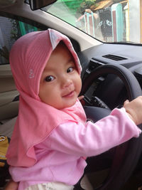 Portrait of cute baby girl in car