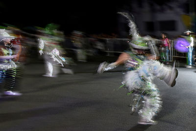 Blurred motion of people on street in city at night