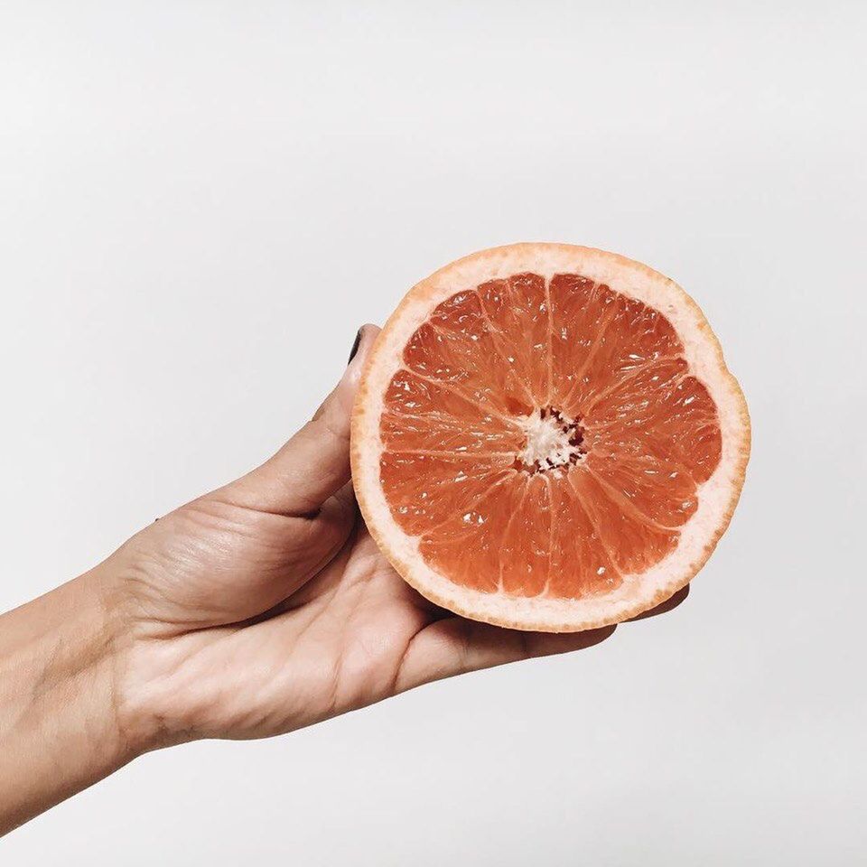 human hand, citrus fruit, studio shot, fruit, healthy eating, orange - fruit, human body part, cross section, slice, food and drink, white background, freshness, food, holding, halved, one person, healthy lifestyle, grapefruit, close-up, blood orange, adult, people, one woman only, day