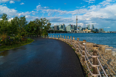 Scenic view of river by buildings against sky