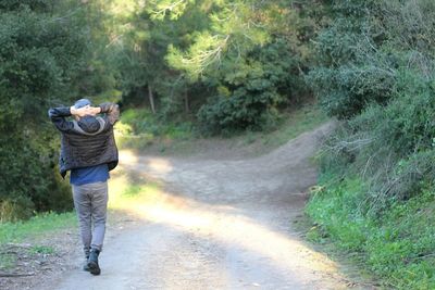 Rear view of man walking on road