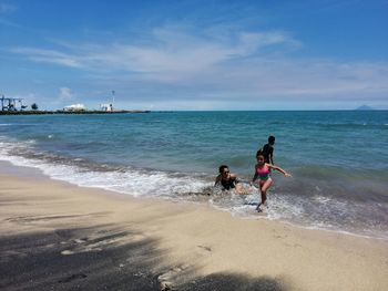 Women on beach against sky